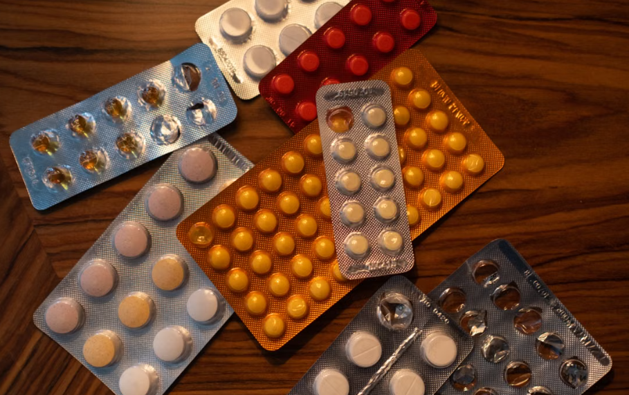 Several part-used blister packs of tablets on a wooden table