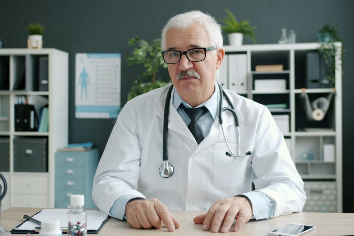 A doctor sitting at a consulting room desk