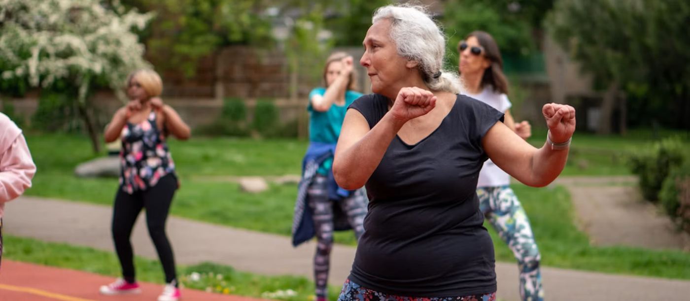 Older adults taking part in an outdoor exercise class on a running track